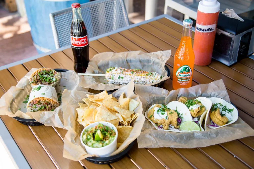 Taco basket, burrito basket, mexican street corn basket, and chips basket with two bottled sodas 