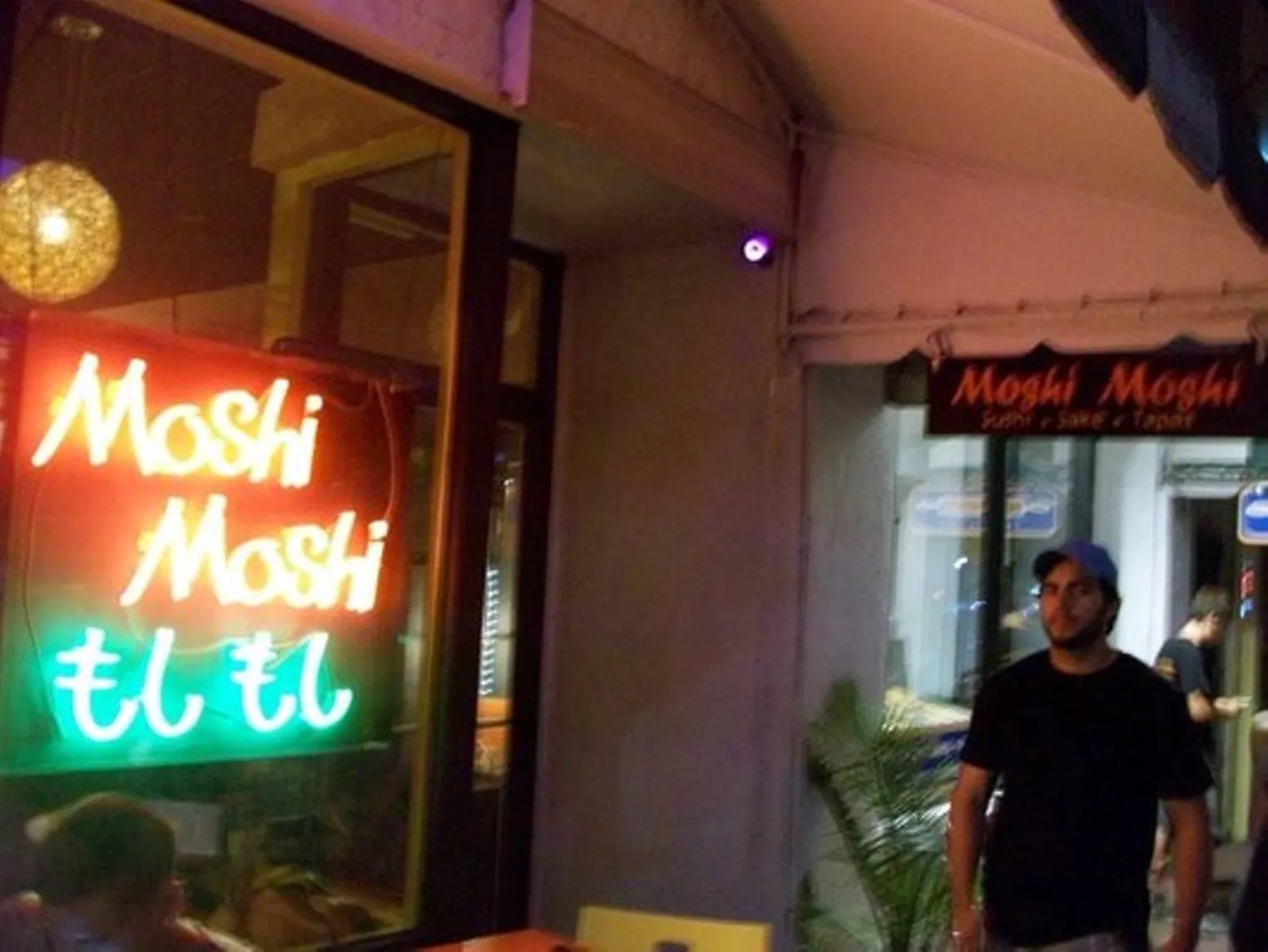 Exterior shot of neon sign buzzing with the name of the restaurant, 