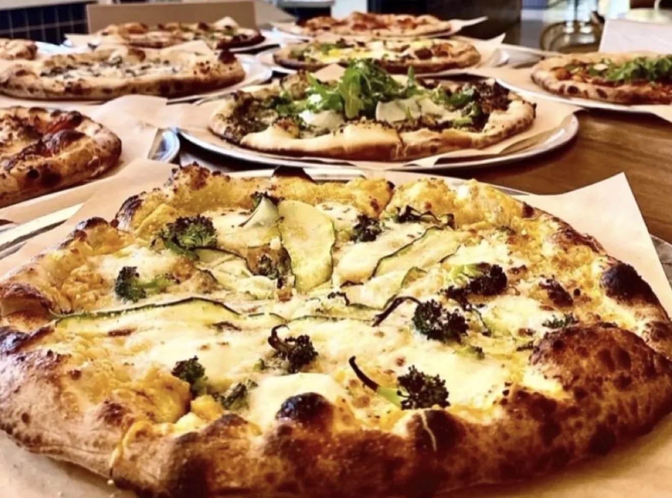 Artisan white pizza with broccoli and zucchini toppings