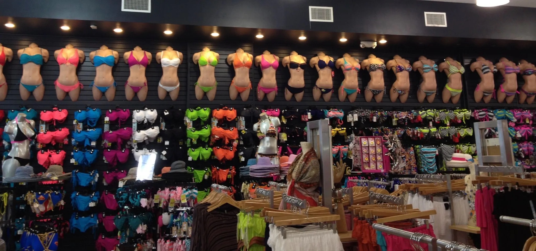 Interior view of Surf Style shop with mannequins in bikinis lining the upper walls and the interior brimming with clothing racks