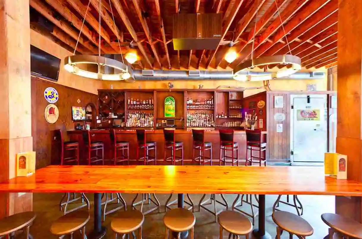 Interior of Abbey Brewing Company with wooden ceiling beams, wooden bar tops and shelving
